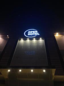 利雅德Open Hotel的夜间酒店顶上的标志