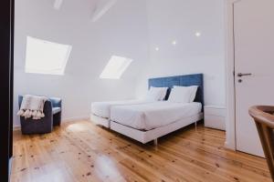 丰沙尔Jaca Hostel Funchal的卧室配有白色的床,铺有木地板