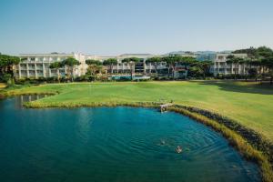 卡斯卡伊斯Onyria Quinta da Marinha Hotel的高尔夫球场的空中景色,有水体