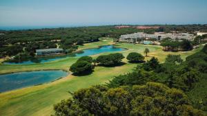 卡斯卡伊斯Onyria Quinta da Marinha Hotel的享有高尔夫球场和湖泊的空中景致