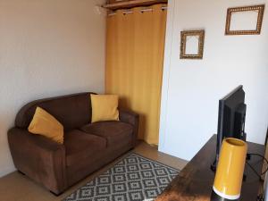 格吕桑Entre port et village的客厅配有棕色沙发和电视