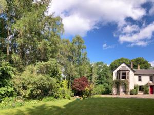 布莱尔高里Heathpark House的一座有树木和草地的院子的房子