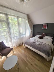 VamaBăile Puturoasa的一间卧室配有一张床、一张沙发和一张桌子