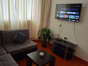 利马201 Departamento exclusivo en Chorrillos的客厅配有沙发和墙上的电视