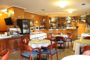 维拉加尔西亚·德·阿劳萨普拉亚孔波斯特拉酒店的一间带桌椅的餐厅和一间酒吧