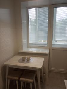乌曼岛Modern fresh-new appartment near the park Sofievka的一张桌子,上面有两杯,房间有两个窗户