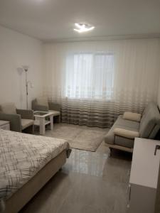 乌曼岛Modern fresh-new appartment near the park Sofievka的一间卧室配有一张床、一张沙发和椅子