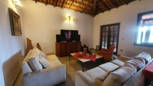 帕蒂杜阿尔费里斯Pousada das Casuarinas的客厅配有两张沙发和一台电视机