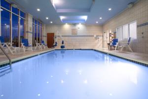 温彻斯特温彻斯特东南历史关口假日酒店的大楼内带蓝色椅子的游泳池