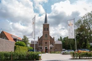 比尔弗利特KerkHotel Biervliet的前面有两面旗帜的教堂