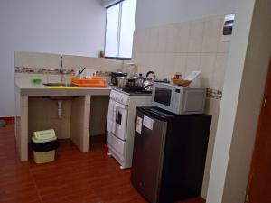 利马200. Hermoso Departamento con Servicios Incluidos en Chorrillos的厨房配有冰箱上方的微波炉