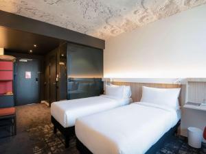 巴库ibis Baku City的酒店客房设有两张床和窗户。