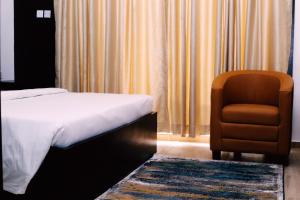 伊凯贾Hotel Capitol的配有一张床和一把椅子的酒店客房