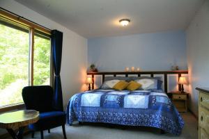 Fall RiverThe Burgundy Dream Bed And Breakfast的卧室配有床、椅子和窗户。