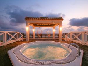 石垣岛Haruhoo Resort ISHIGAKI的甲板上的热水浴池,带凉亭