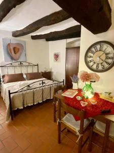 皮蒂利亚诺La Tana del Grillo的卧室配有一张床,墙上挂着一个钟