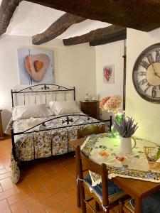 皮蒂利亚诺La Tana del Grillo的一间卧室配有一张床、一张桌子和闹钟