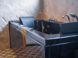 因泽尔Sauna & Whirlpool - ALPENLIEBE APARTments的客房内的浴缸配有水槽和椅子