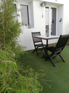 里夫杜海滩COUP DE COEUR Studio的草坪上摆放着一张桌子和两把椅子