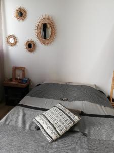 里夫杜海滩COUP DE COEUR Studio的一张带枕头的床和墙上的三面镜子