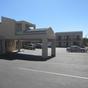 滨海城Pacific Best Inn的停车场内有车辆的建筑物