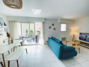 鲁瓦扬Le Pontappart的客厅配有蓝色的沙发和桌子