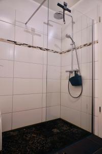 霍恩维舍多夫FEWO Sanddorn的浴室铺有白色瓷砖,设有淋浴。