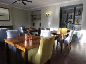 海姆维尔Sani Pass Manor Guest House的用餐室配有木桌和椅子