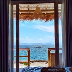 珀尼达岛VnS Beachfront Guesthouse的卧室设有海景窗户。