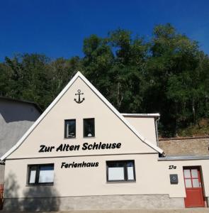 WettinFerienhaus Zur alten Schleuse的白色的建筑,上面有标志