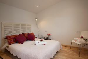 巴塞罗那Homenfun Barcelona Montjuic的卧室配有带红色枕头的大型白色床