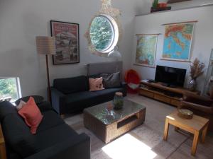 斯塔茨卡纳尔Tintaglia, betaalbaar en gastvrij的带沙发和电视的客厅