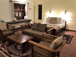 马拉利库兰Mandaram villas的一间卧室配有一张床、一张沙发和一张桌子