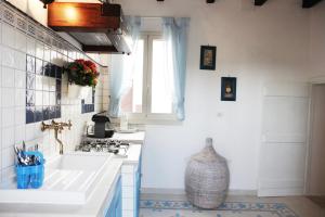 卡萨拉诺La Casina Della Quiete的白色的厨房设有水槽和窗户