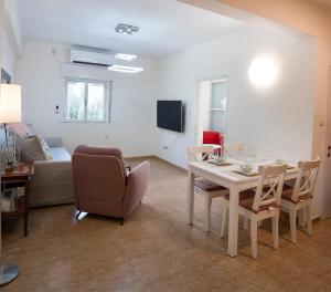 耶路撒冷Eyni Lovely Boutique Apartment的客厅配有桌椅和沙发