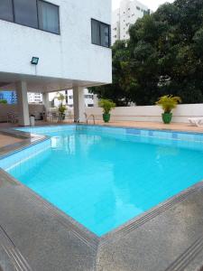 累西腓Hotel Nacional Inn Recife Aeroporto的一座大型蓝色游泳池,位于大楼旁边