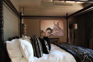 Tom BurkePalala Boutique Game Lodge and Spa的卧室配有一张壁挂式海报的床