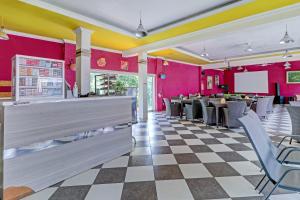 万隆Super OYO Collection O 90617 Rumah Oma Opa Syariah的餐厅拥有粉红色的墙壁和 ⁇ 格地板