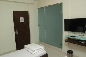 孟买Hotel Causeway, Colaba的一间带电视和凳子的房间