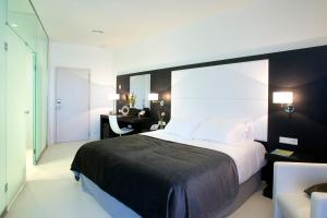 略夫雷加特河畔奥斯皮塔莱特费拉港四星超级酒店的一间卧室配有一张大床和一张书桌