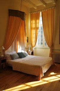 Labastide-du-Vert拉穆林酒店的一间卧室配有带橙色窗帘的大床