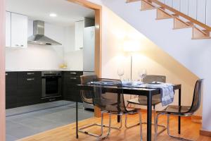 略夫雷加特河畔奥斯皮塔莱特费拉复式公寓的厨房配有黑色的桌椅和楼梯