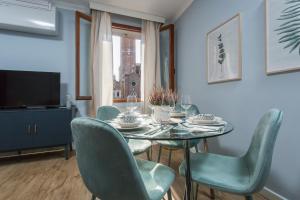 威尼斯Suite Veronica & Maison Laguna的一间带桌椅和电视的用餐室