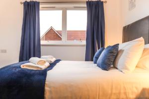 滨海纽比金Cosy - Modern - Accommodation - In Heart of Northumberland的一间卧室配有一张带蓝色窗帘的床和一扇窗户