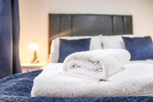 滨海纽比金Cosy - Modern - Accommodation - In Heart of Northumberland的床上铺有白色毛巾的床