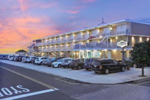 威尔伍德克拉斯特格拉纳达海洋度假胜地汽车旅馆的停在大楼前的一排汽车