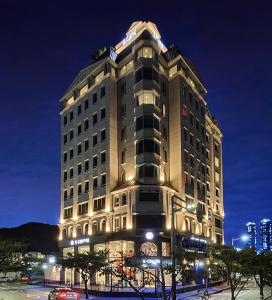 釜山AG405 Hotel的一座高大的建筑,晚上有灯
