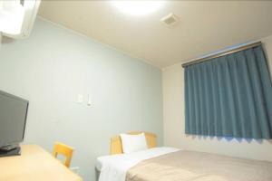 藤枝Fujieda Ogawa Hotel フジエダオガワホテル的客房设有两张床、一台电视和一扇窗户。