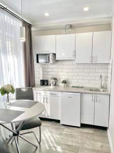 伊尔平Элегантная квартира-студия ЖК Рич Таун, Ирпень的厨房配有白色橱柜和桌子