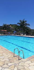 圣佩德罗-达阿尔德亚Residencial Marina Club的一座拥有蓝色海水和棕榈树的大型游泳池